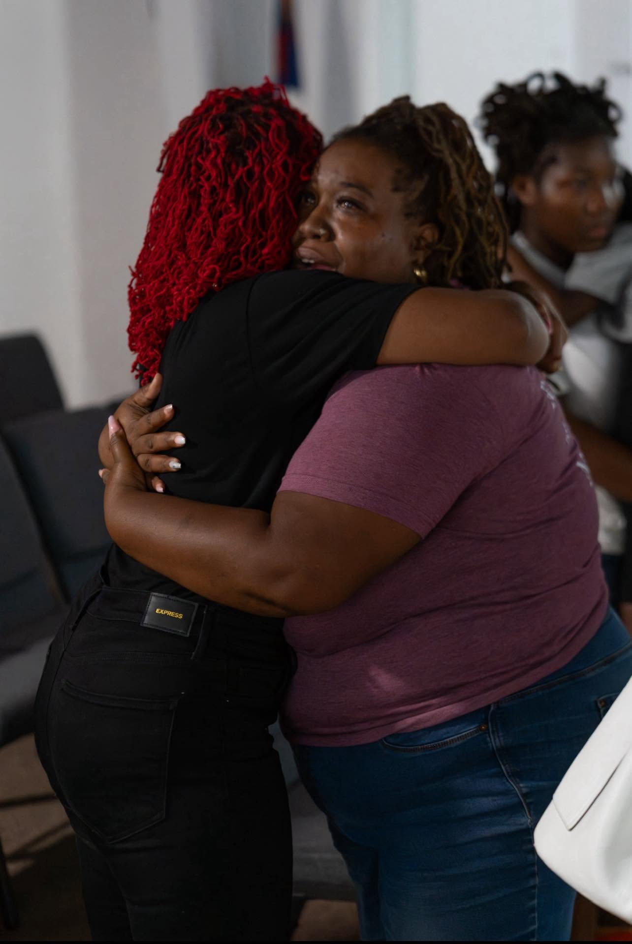 Two sisters embracing after worship