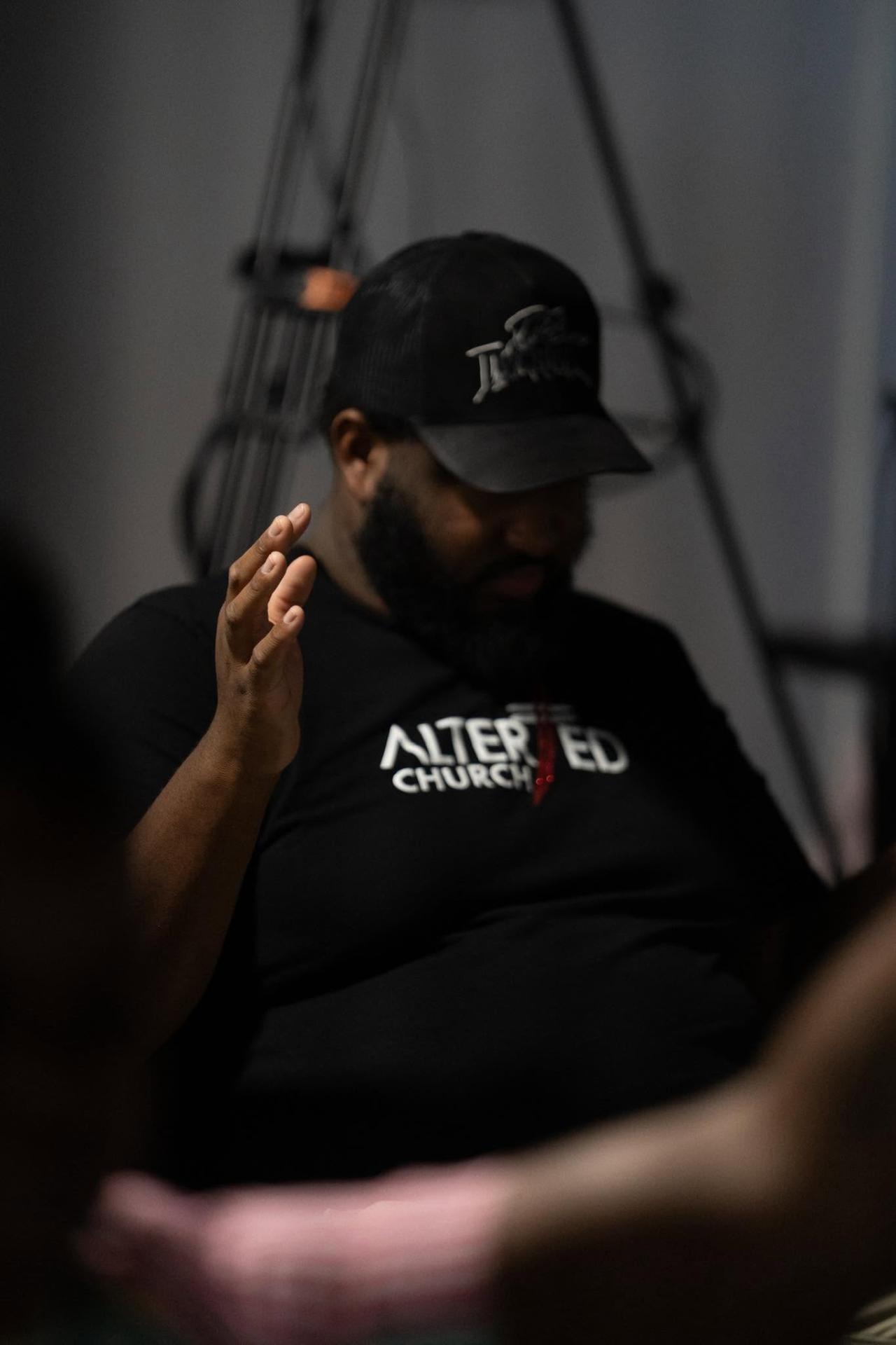 Member in prayer wearing Altered Church gear